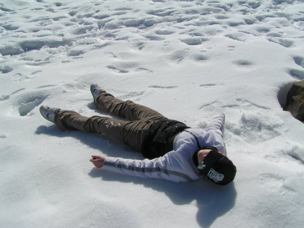 Мальчик лежит в сугробе