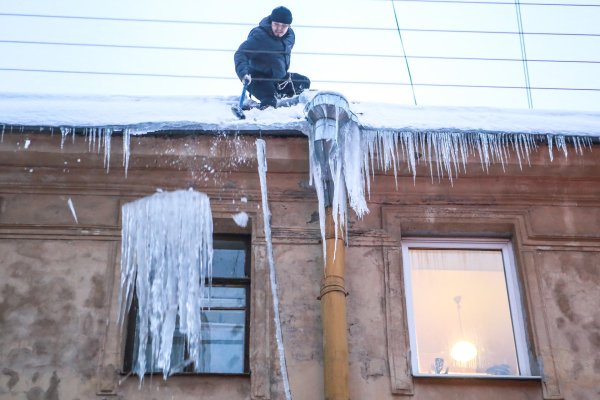 Дворник сбивает сосульки