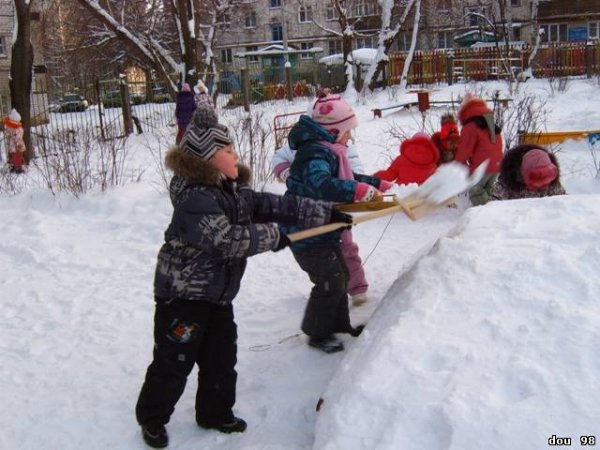 Дети строят горку зимой