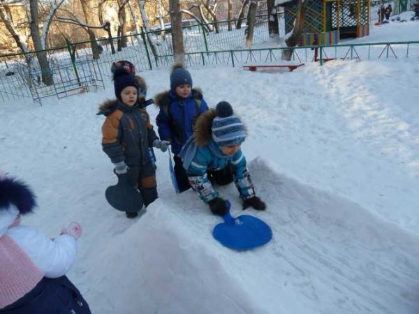 Дети строят горку из снега