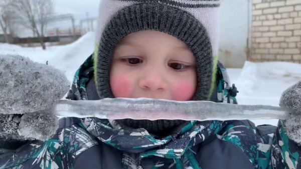 Мальчик ест сосульку
