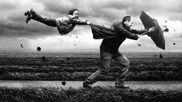 Мужчина идет против ветра