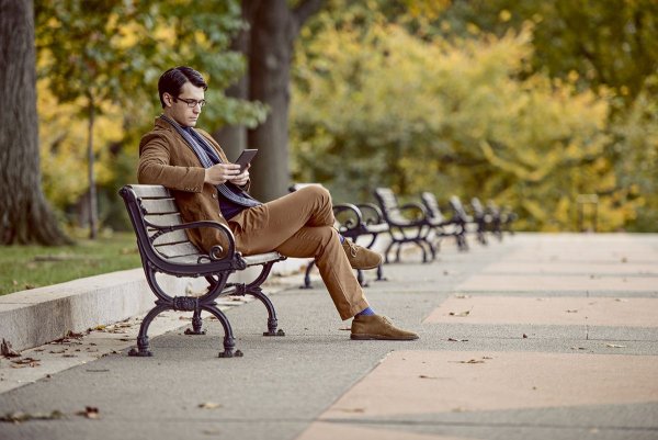 Человек сидит на лавочке в парке