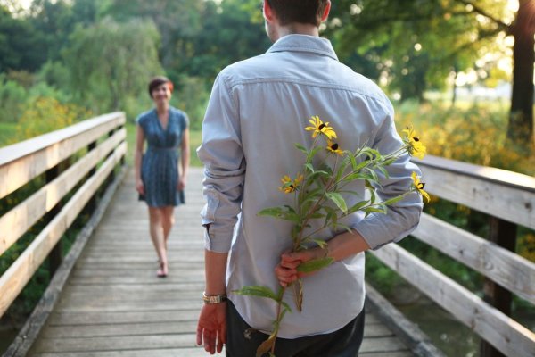 Парень ждет девушку с цветами