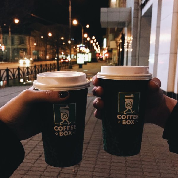 Стакан кофе в руках на улице