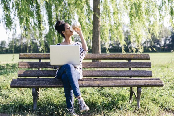 Девушка с ноутбуком на скамейке