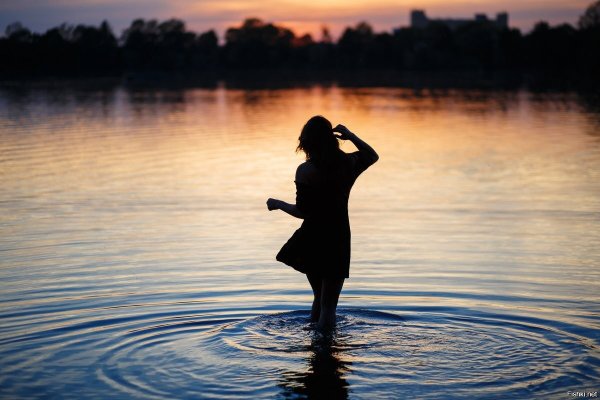 Девушка на озере со спины