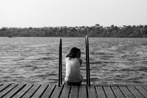 Девушка на берегу озера со спины