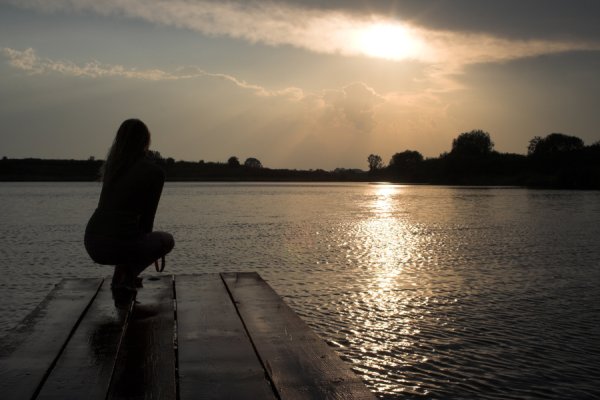 Девушка у реки вечером