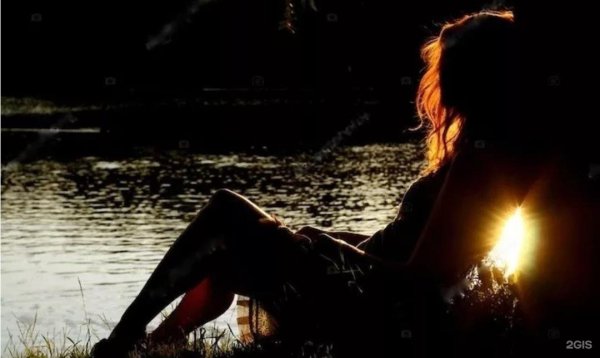 Девушка у реки со спины