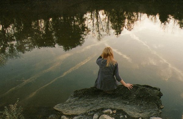 Блондинка у реки со спины