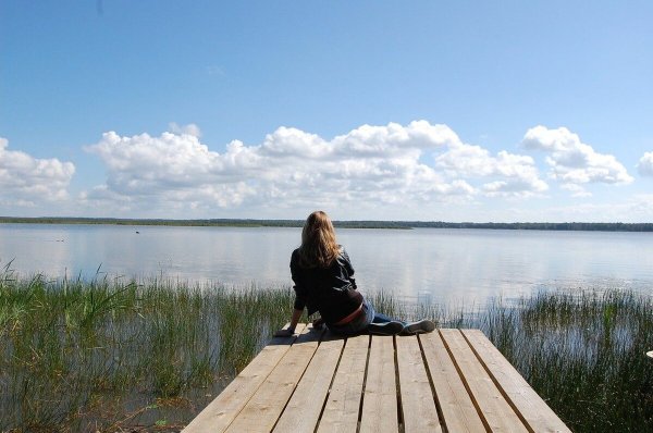 Девушка у реки со спины