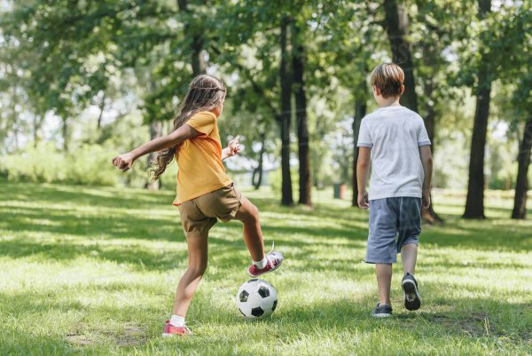 Дети играют в мяч на газоне