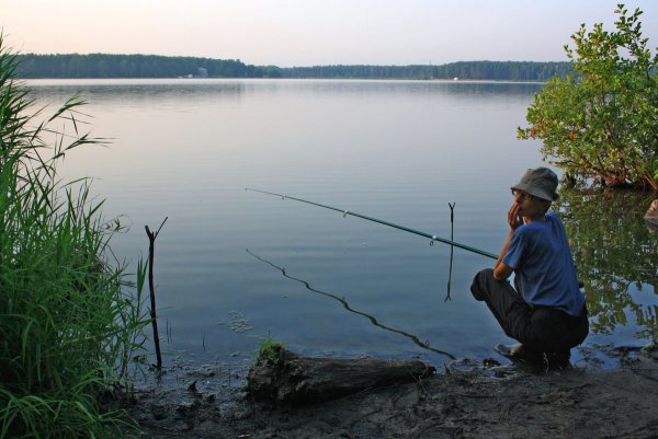 Рыбак с удочкой на озере