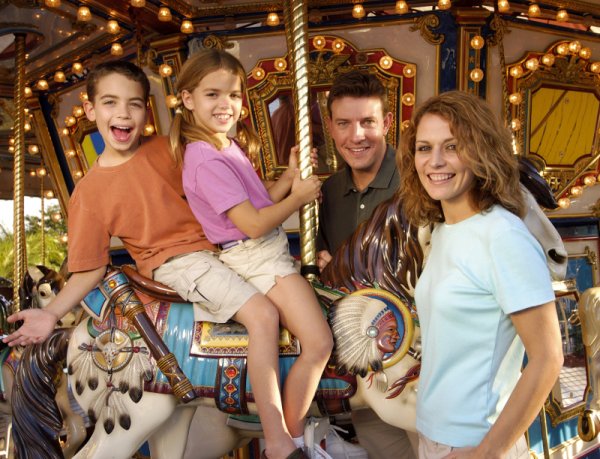 Семья с детьми в парке аттракционов