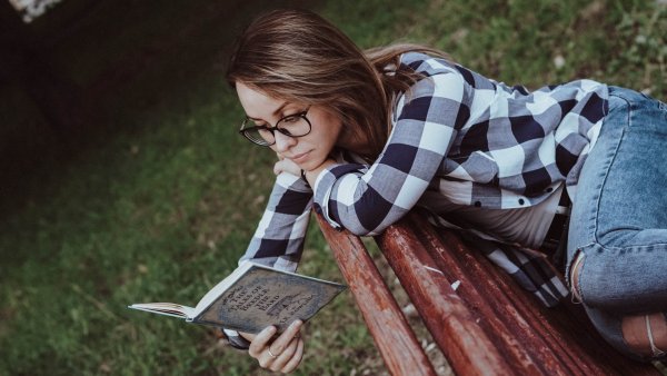 Человек читает книгу в парке