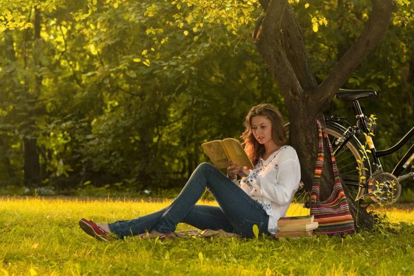 Девушка читает книгу в парке