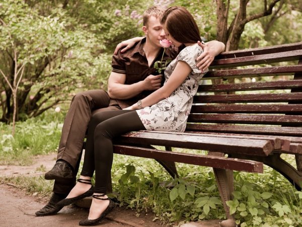 Парень и девушка сидят на скамейке