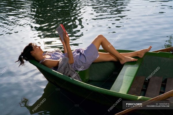 Женщина читает в лодке