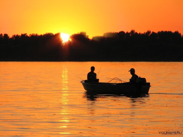 Рыбак в лодке на закате