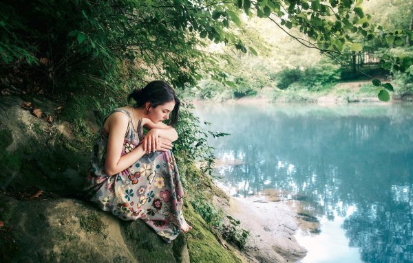 Девушка сидит у реки