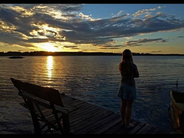 Девушка на берегу реки на закате