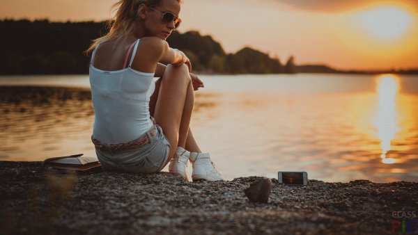Девушка сидит на берегу