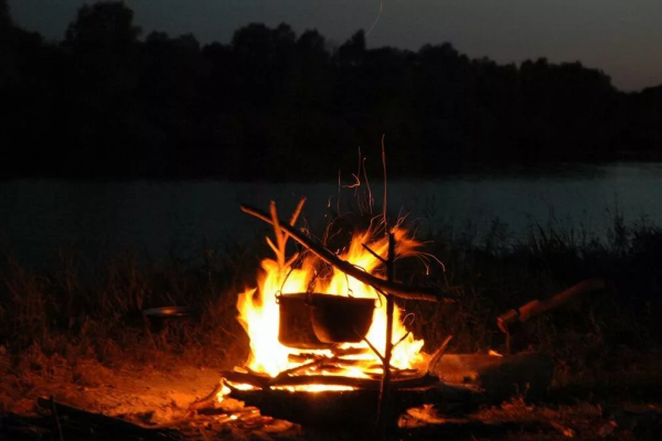 Костер на берегу реки ночью