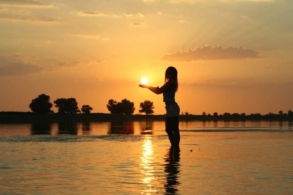 Девушка на берегу реки на закате