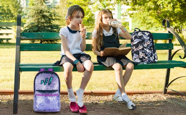 Школьники сидят на скамейке