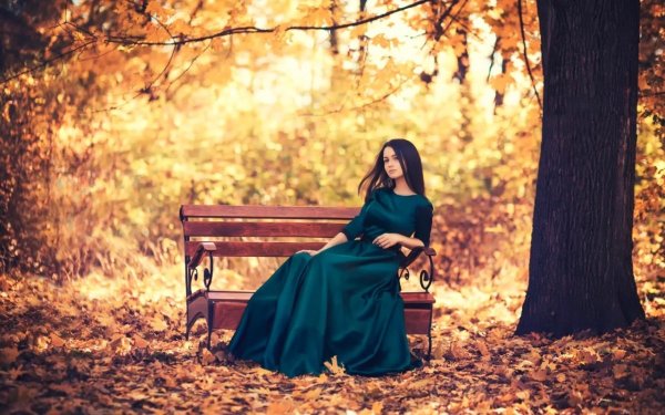 Девушка в длинном платье сидит