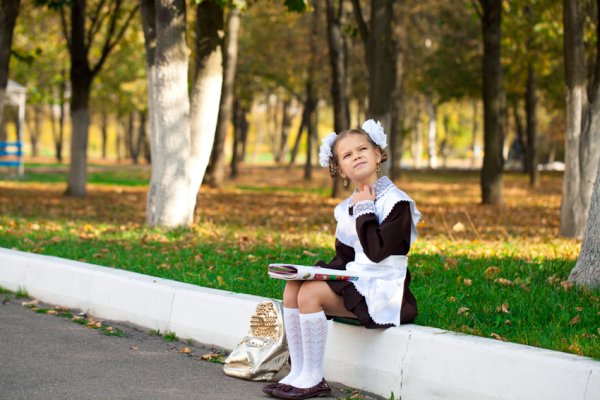 Девочка в школьной форме сидит