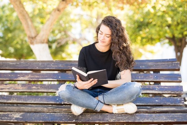 Девушка с книжкой на скамейке