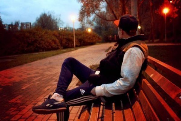 Парень без лица сидит на лавке