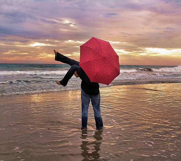 Девушка с красным зонтом у моря