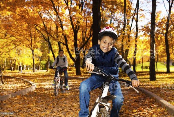 Мальчик катается на велосипеде в парке