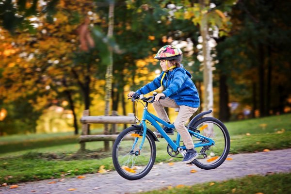 Мальчик едет на велосипеде в парке