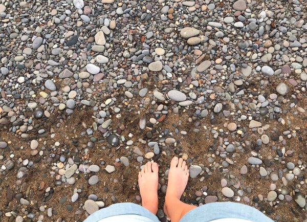Ноги на галечном пляже