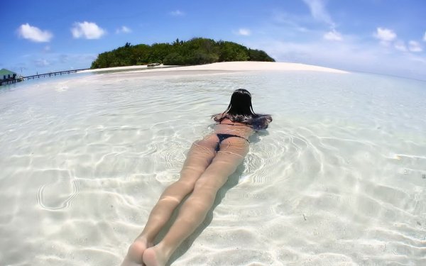Девушка в воде на берегу острова