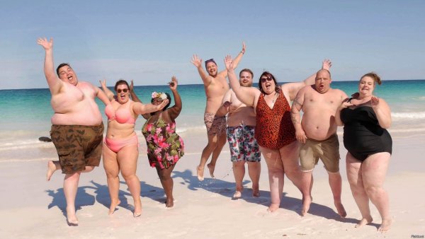 Полные люди на пляже