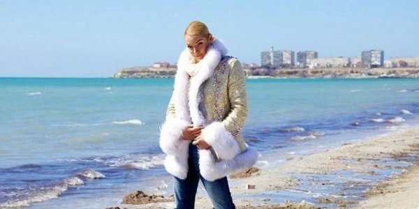 Девушка в шубе на море