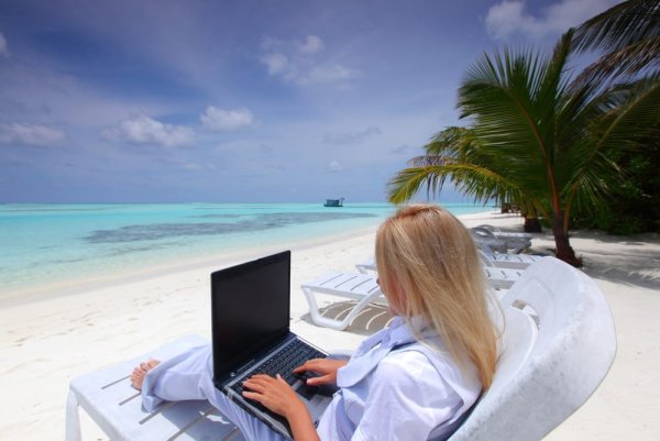 Девушка с ноутбуком на берегу океана