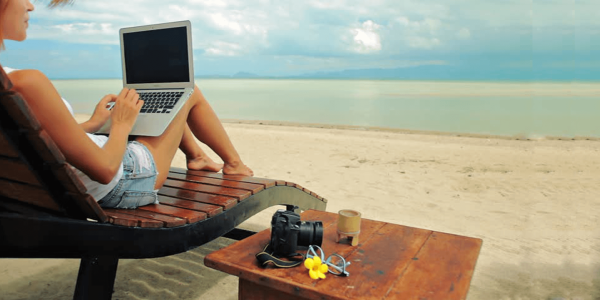 Девушка с ноутбуком на берегу моря