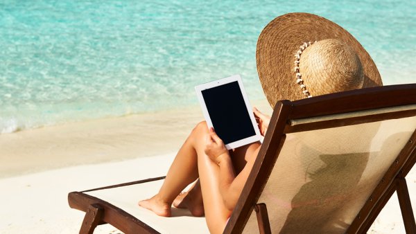 Девушка в шляпе на пляже на шезлонге