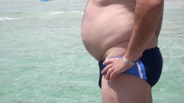 Мужчины с пивным животом на пляже