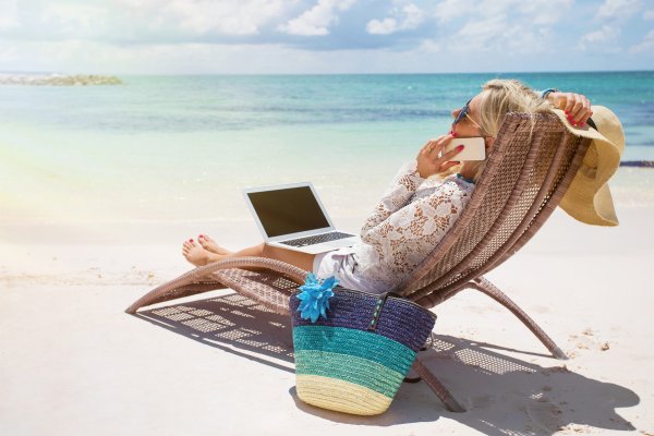 Девушка с ноутбуком на берегу моря