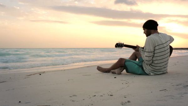 Парень с гитарой на берегу моря