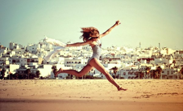 Девушка танцует на пляже