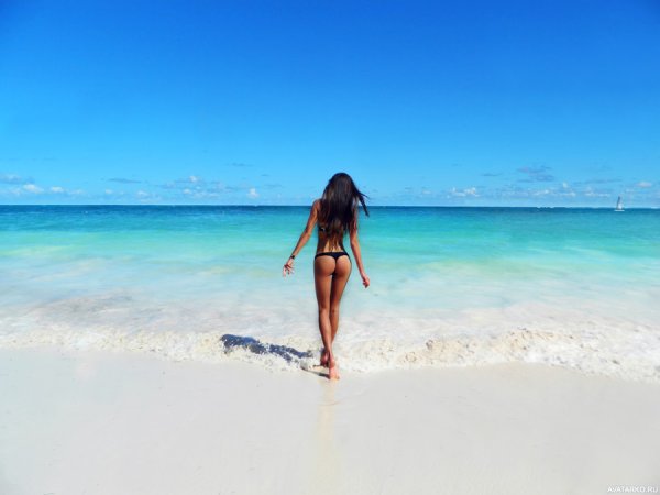 Брюнетка на море со спины