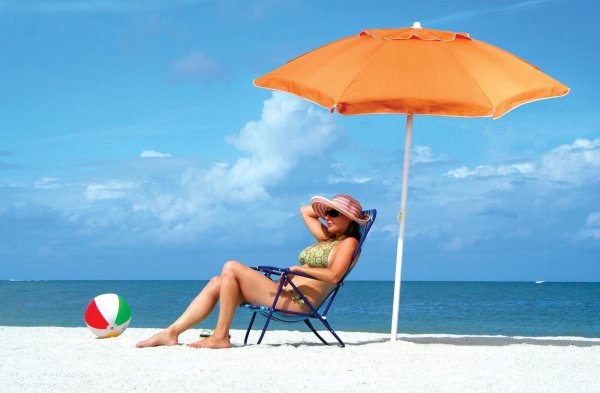 Человек под зонтом на пляже